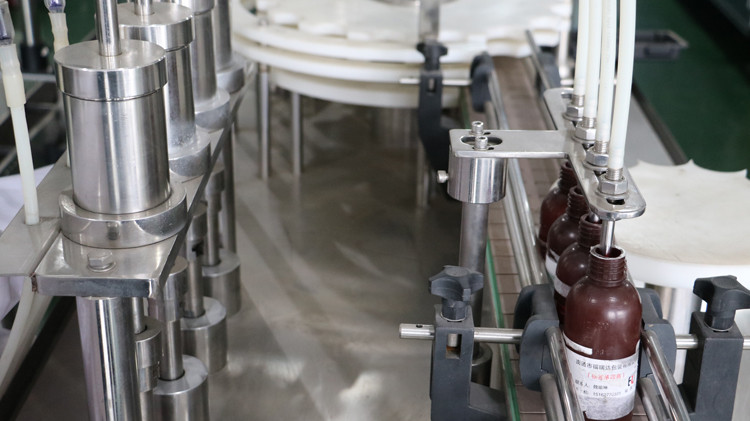 500 ml-es kerek palackozó gép kupakkal lezárva és csillagkerékkel futva